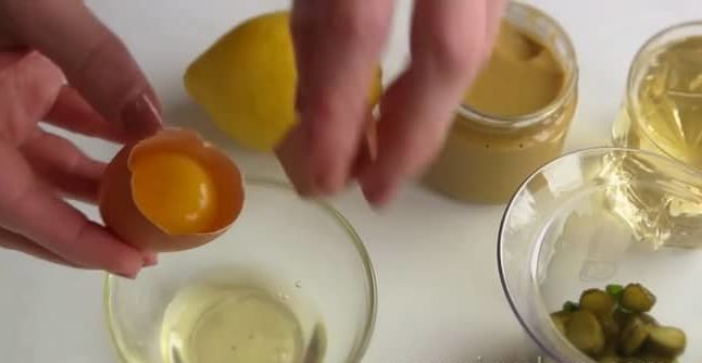 Чтобы приготовить классический соус тартар, отделите яичный белок от желтка.