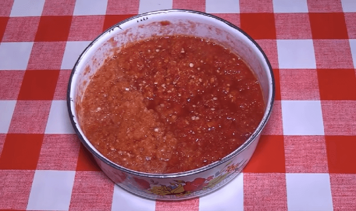 Измельчите перец и чеснок в мясорубке и добавьте к помидорам.